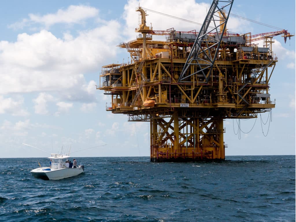 Anglers in a center-console fishing boat ready to fish a Gulf of Mexico oil rig