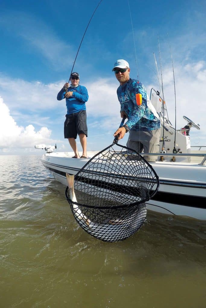 netting redfish from boat using popping cork inshore saltwater fishing tackle